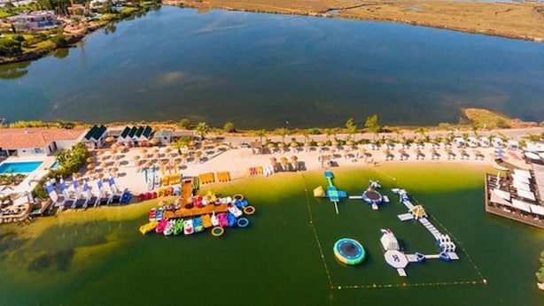An aerial view of a coastal resort with a swimming pool, beach umbrellas, and a water park. - Scarlet's Place - Spacious 1 bed Quinta Do lago (Quinta do Lago)