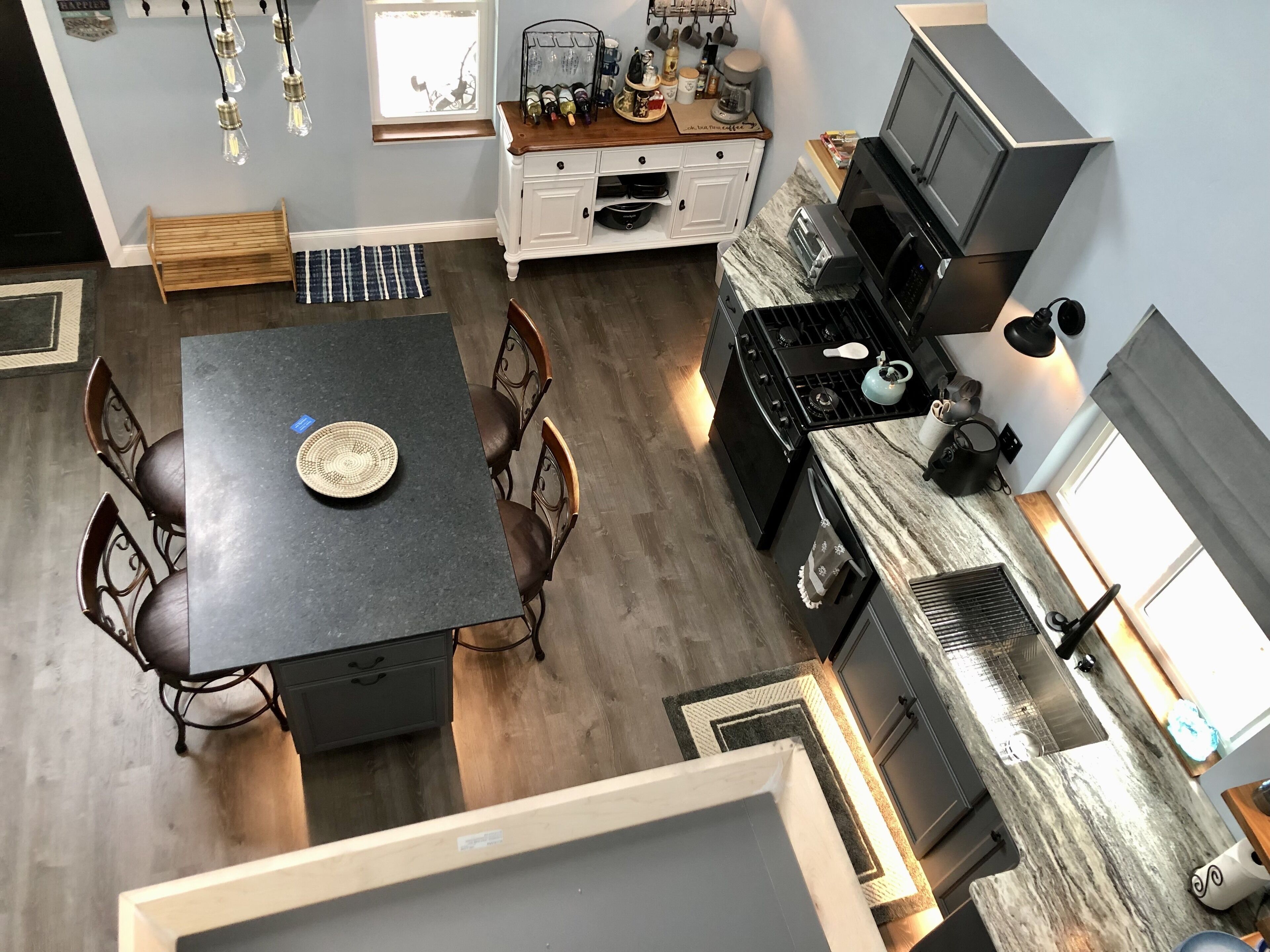 Een moderne keuken met een centraal eiland, een eethoek met stoelen en een ingebouwde oven.