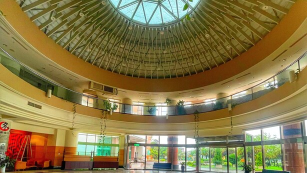 A spacious lobby with a high ceiling and a central skylight, featuring a geometric glass ceiling and a polished floor with geometric patterns. - apvc-resort (Lukang)