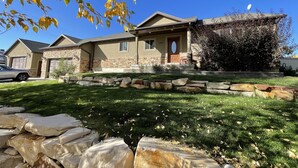 A two-story house with a stone facade, a front porch, and a garage. - Beautiful Getaway Near Park City with Private Hot Tub (Kamas)