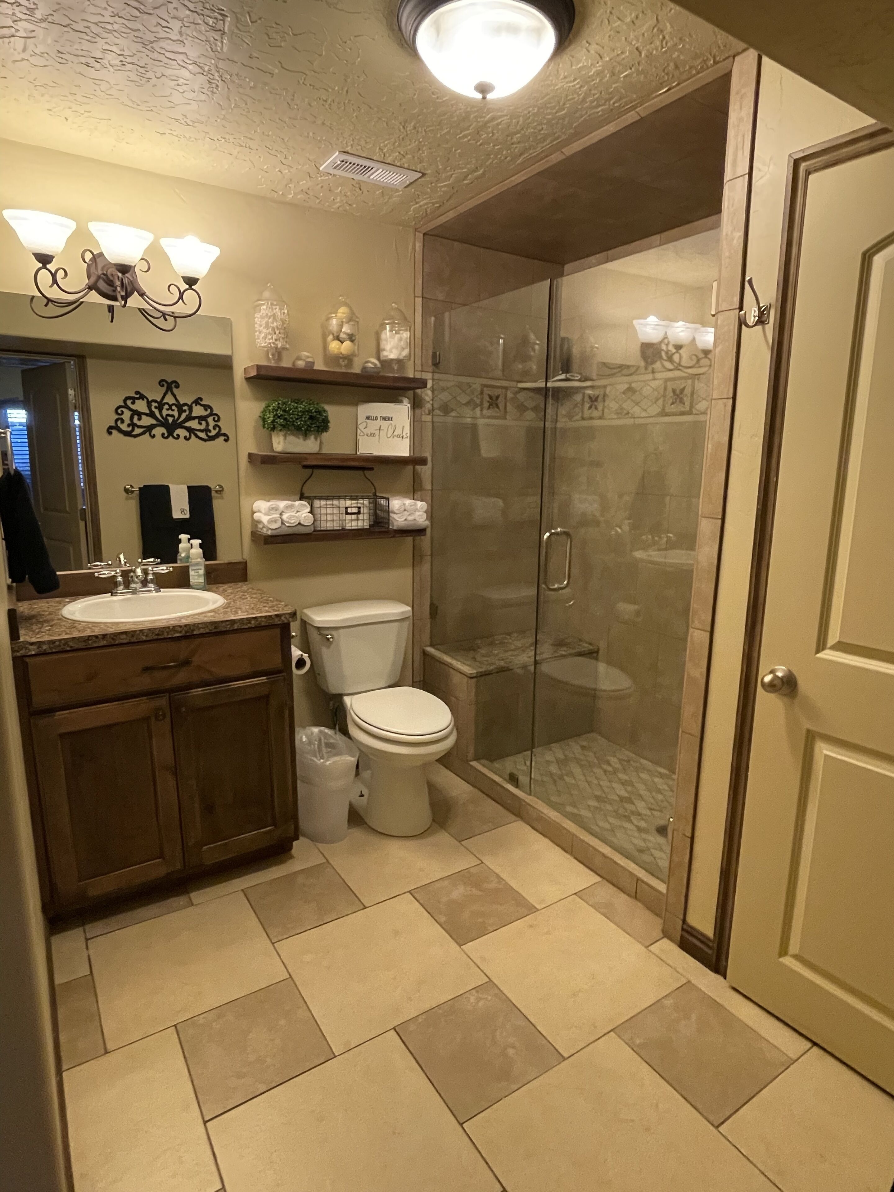 A modern bathroom with a glass-enclosed shower, a vanity with a sink, and a toilet.
