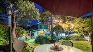 Un espacio de comedor al aire libre con una mesa, sillas y un farol.