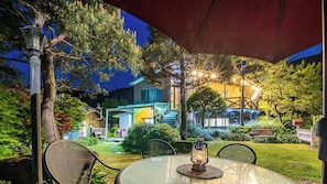 An outdoor dining area with a table, chairs, and a lantern. - Gapyeong Ojeupension (Gapyeong)