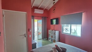 Un dormitori amb llit, televisió, armari i finestra.
