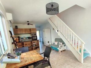 Un amplio espacio habitable con una mesa de comedor, sillas, un sofá y una escalera.