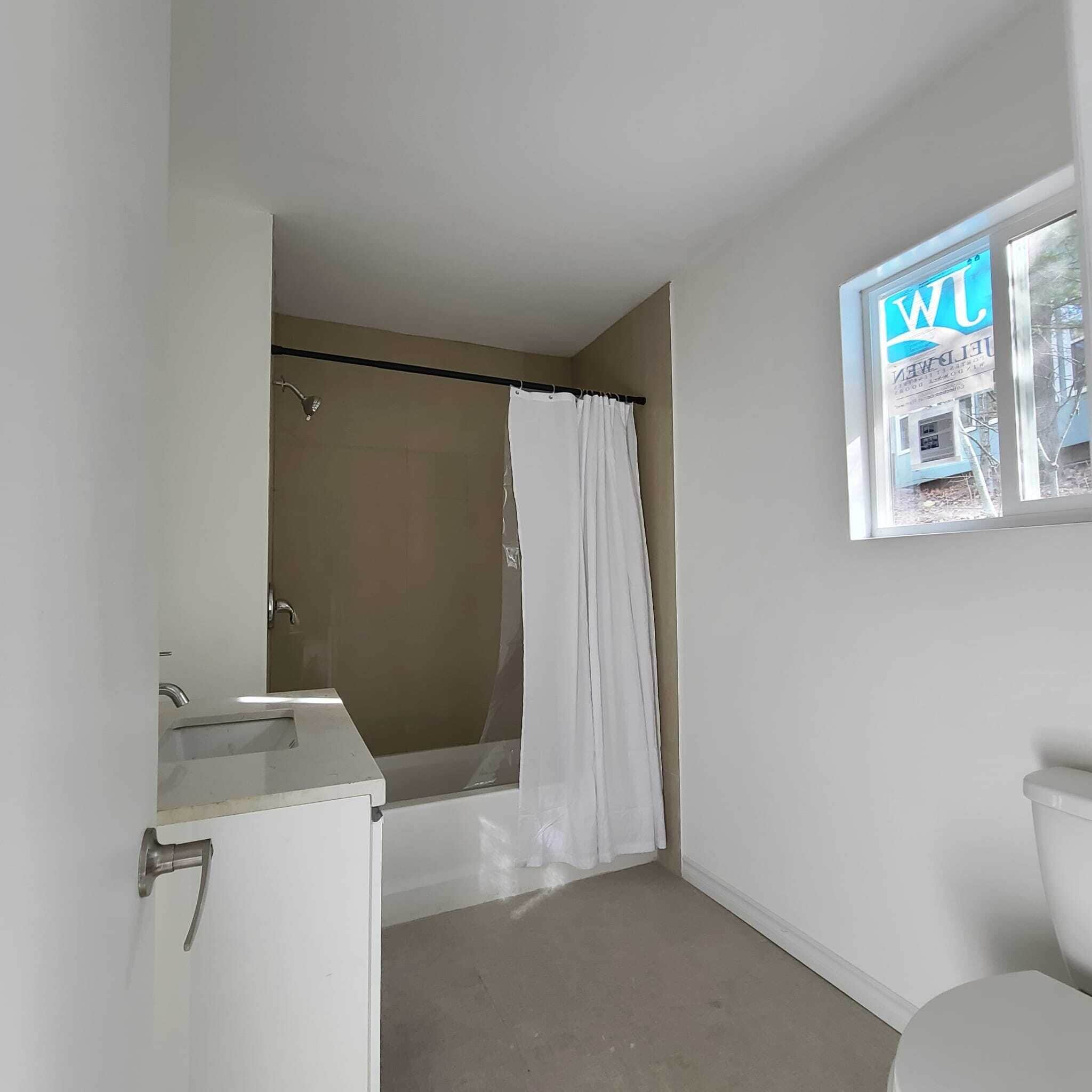 Ein Badezimmer mit einer Badewanne, einer Toilette und einem Waschbecken.