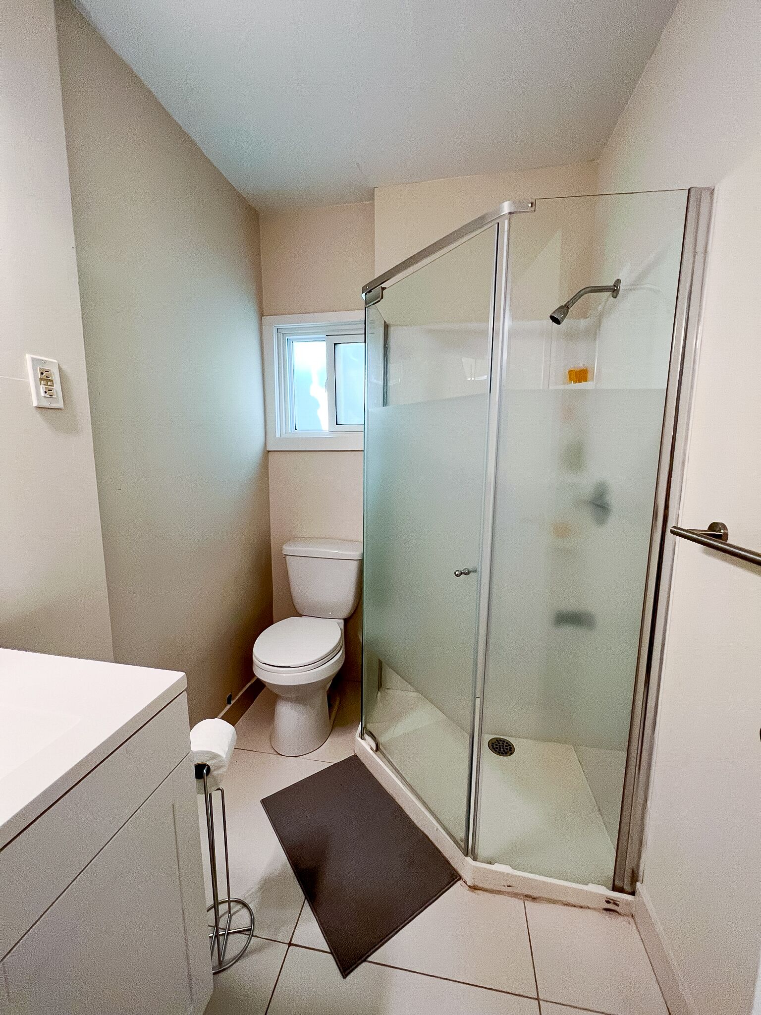 Un bagno moderno con doccia vetrata, un water e un lavandino.
