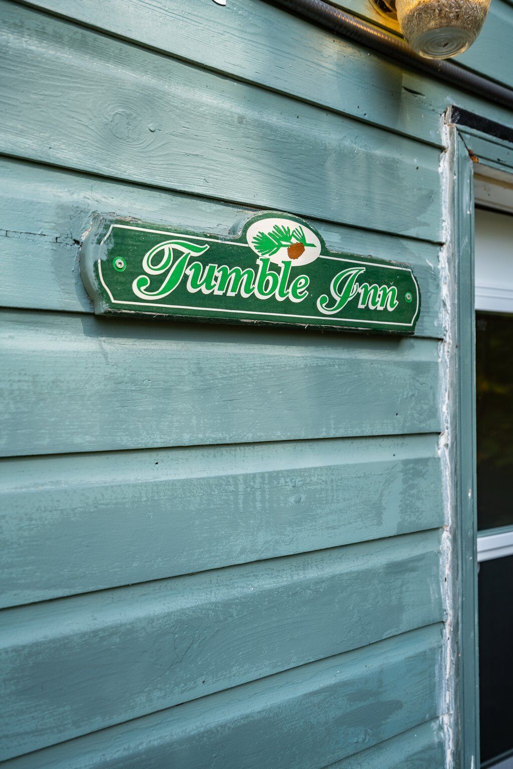 A green sign with the text "Fumble Inn" and a logo of a leaf and acorn.