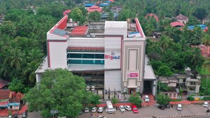 A large shopping mall with a prominent 'Big Mall' sign, surrounded by lush greenery and residential buildings. - Big Mall Residency (Hosdurg)