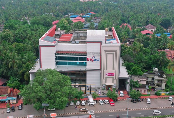 A large shopping mall with a prominent 'Big Mall' sign, surrounded by lush greenery and residential buildings. - Big Mall Residency (Hosdurg)