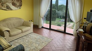 A living room with a beige sofa, a patterned rug, and a large painting on the wall.