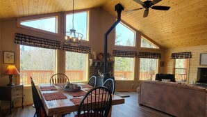 A cozy cabin interior with a dining area, a fireplace, and a living room. - Welcome to Duck Creek Haven A fully furnished cabin secluded in a serene setting (Duck Creek Village)