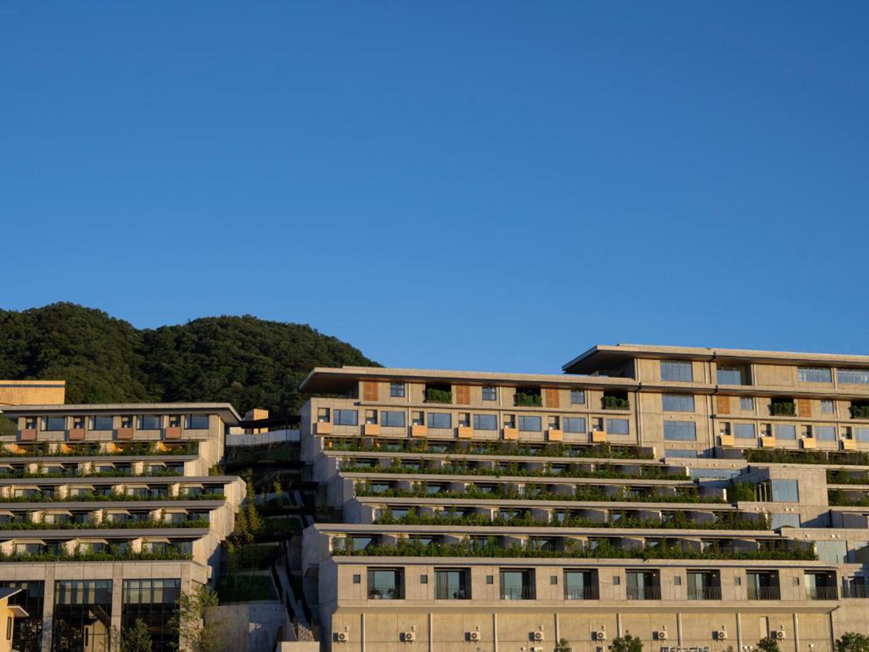 A modern multi-story building with a flat roof and balconies.