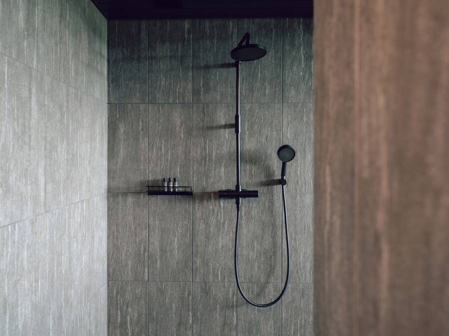 A modern shower with a handheld showerhead and a handheld faucet.
