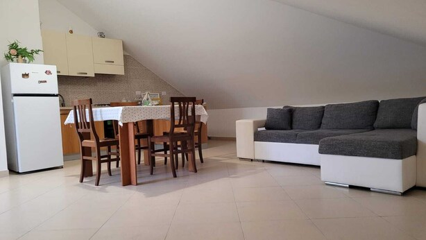 A compact living space with a dining area, kitchenette, and a sofa. - Lovely attic room (Sant'Agata di Militello)