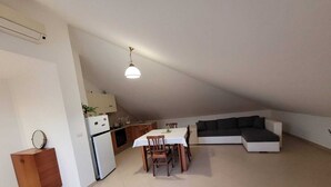 A compact living space with a kitchenette, a dining area, and a seating area. - Lovely attic room (Sant'Agata di Militello)