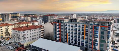 A modern hotel with multiple floors, a parking lot, and a view of the cityscape.