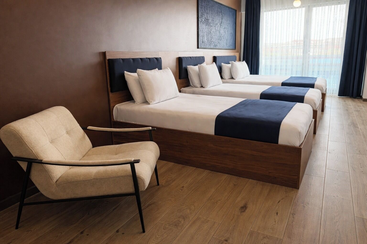 A hotel room with a bed, a chair, and a small table.