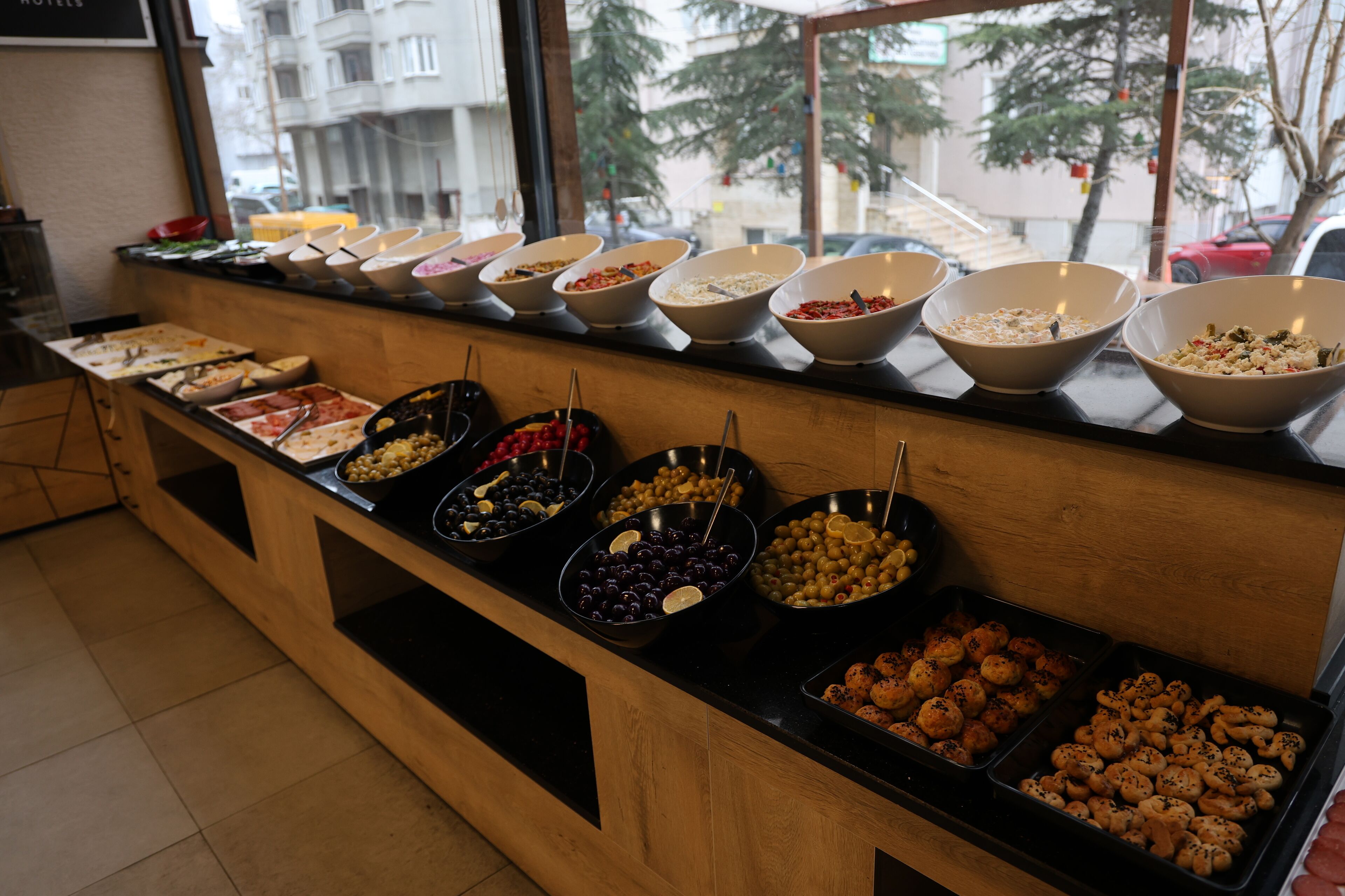 Un bufé con diversos alimentos dispuestos en cuencos y bandejas.