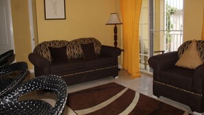 A living room with two sofas, a lamp, and a framed picture on the wall.