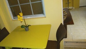 A yellow table with a potted plant, a window, and a 'Welcome' mat.