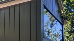 Ein modernes Gebäude mit Backsteingrund und großen Fenstern.