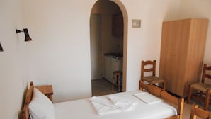 A room with two wooden beds, a wooden wardrobe, and a wooden chair. - Julieta's House (Alonissos)