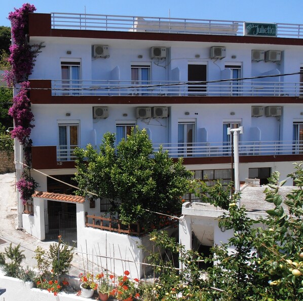 A multi-story hotel with balconies, air conditioning units, and a sign reading "Hotel Julietta". - Julieta's House (Alonissos)