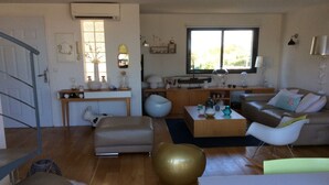 Una sala de estar moderna con sofá, mesa de centro y un ventanal grande.