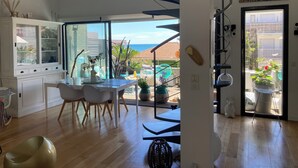 Un interior moderno con comedor, cocina y vista al mar.
