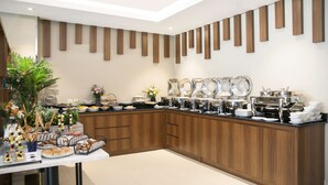 Una cocina moderna con armarios de madera, un bufé con diferentes platos y una planta decorativa.