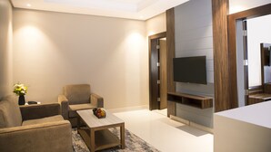 Una sala de estar moderna con un sofá, una mesa de centro y un televisor de pantalla plana montado en una pared de madera.