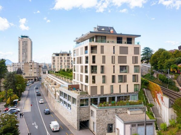 Um hotel de vários andares com design moderno, com varandas e fachada de pedra.