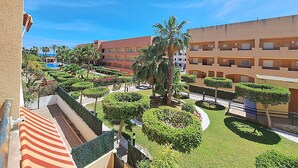 A hotel courtyard with a pool, palm trees, and a building with multiple balconies. - Nassau - Apartment with terrace and pool in Vera Playa (Vera playa)