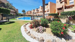 A resort with a swimming pool, palm trees, and a well-maintained garden. - Nassau - Apartment with terrace and pool in Vera Playa (Vera playa)
