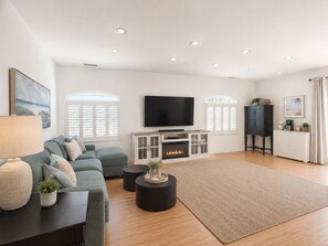 A modern living room with a fireplace, a television, and a sofa.