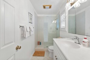 A bathroom with a white sink, a mirror, a shower, and a toilet. - Luxury Beach House 99 Steps from Sand, Pet-friendly (Ventura)