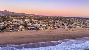 A coastal town with a beach, houses, and a mountain in the background. - Luxury Beach House 99 Steps from Sand, Pet-friendly (Ventura)