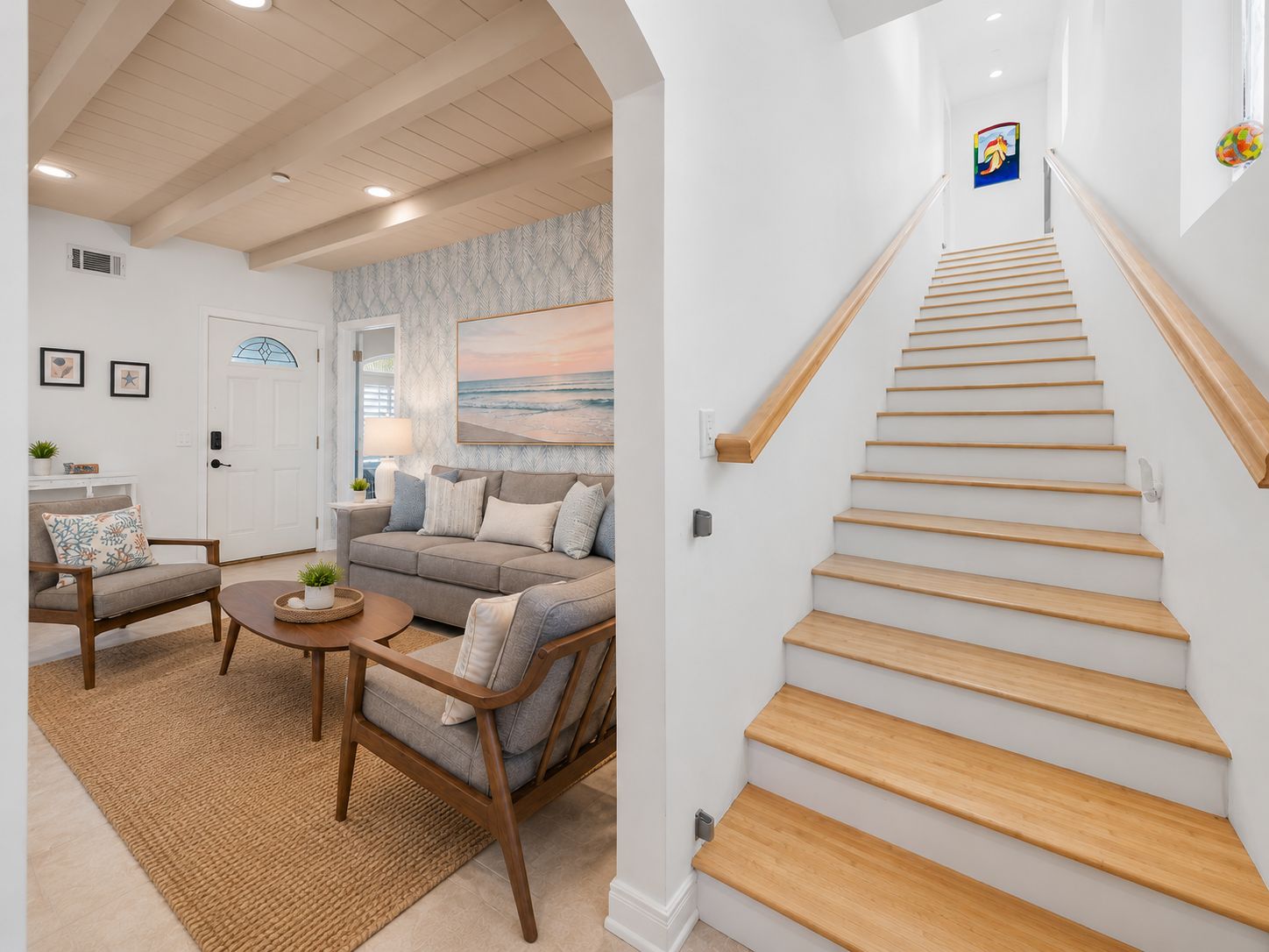 Een modern interieur met een trap, een zithoek en uitzicht op de oceaan.