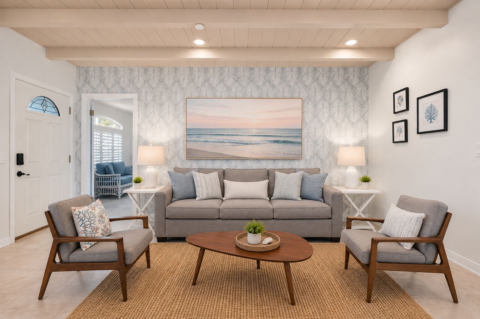 A living room with a grey sofa, two armchairs, a coffee table, and a large painting of a beach scene.