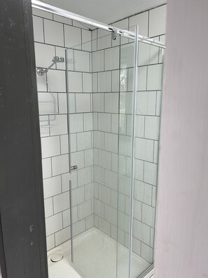 Chuveiro, toalhas de banho, sabonete, papel higiênico