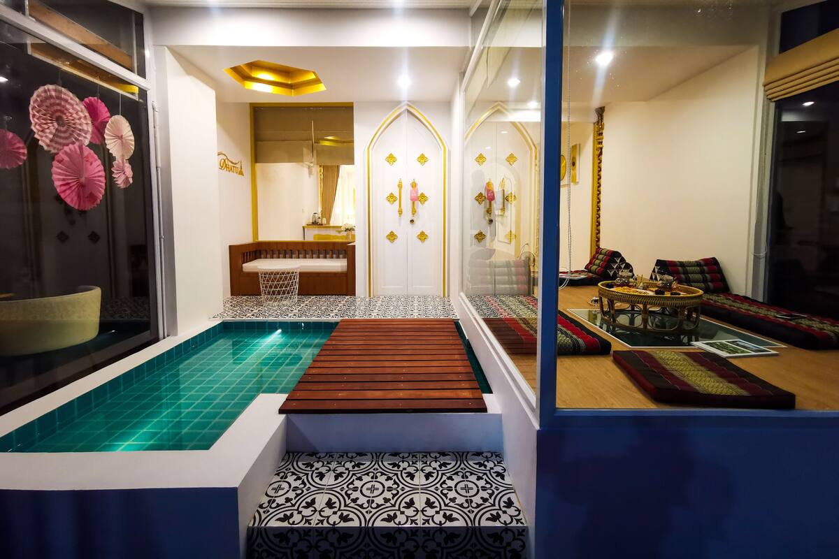 Un intérieur moderne avec une piscine, un coin salon et un espace repas.