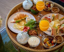 Un bufé de desayuno con cruasanes, sándwiches, fruta y bebidas.