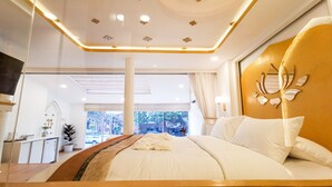 Un dormitorio moderno con una cama grande, cabecera de madera e iluminación empotrada en el techo.
