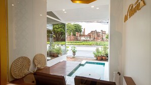 Un interior moderno con vista a la piscina, muebles de madera y una pared de cristal.