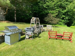 A backyard with a barbecue grill, a wooden swing set, and a red bench. - 6 Minute Walk to Mountain Top Inn 4 BR, Sleeps 10, Pet Friendly, Views & Grill (chittenden)