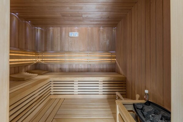 Una sauna con bancos de madera y un banco con calefactor.