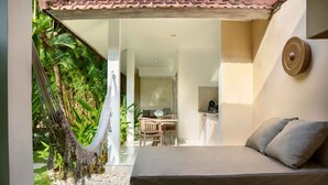 Una habitación con cama, una hamaca y vistas a un comedor.