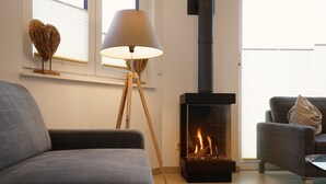 En moderne stue med pejs, gulvlampe og to sofaer.