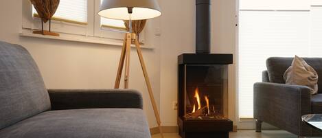 Una sala de estar moderna con chimenea, una lámpara de pie y dos sofás.